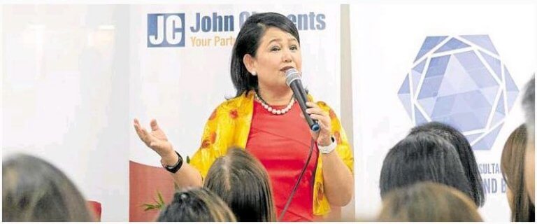 A Filipino woman speaking to a crowd. Women in leadership concept.