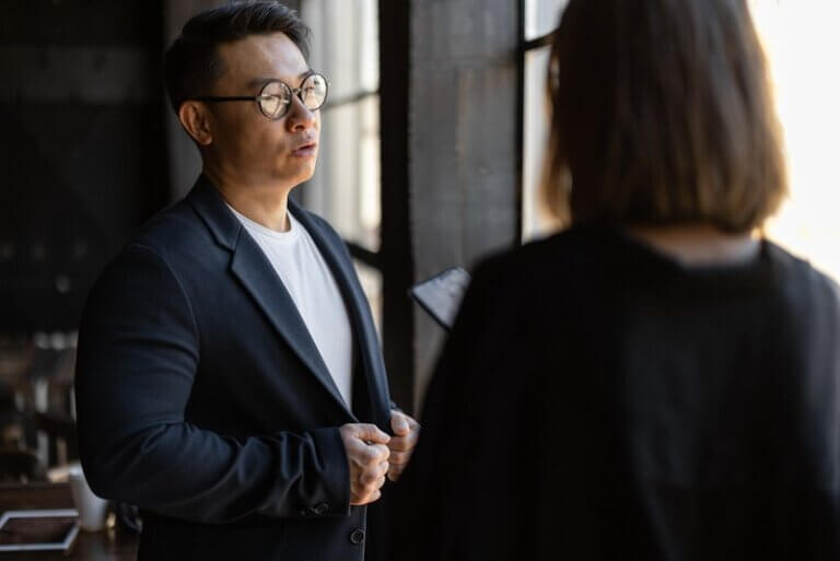 Man in conversation with a woman by a window