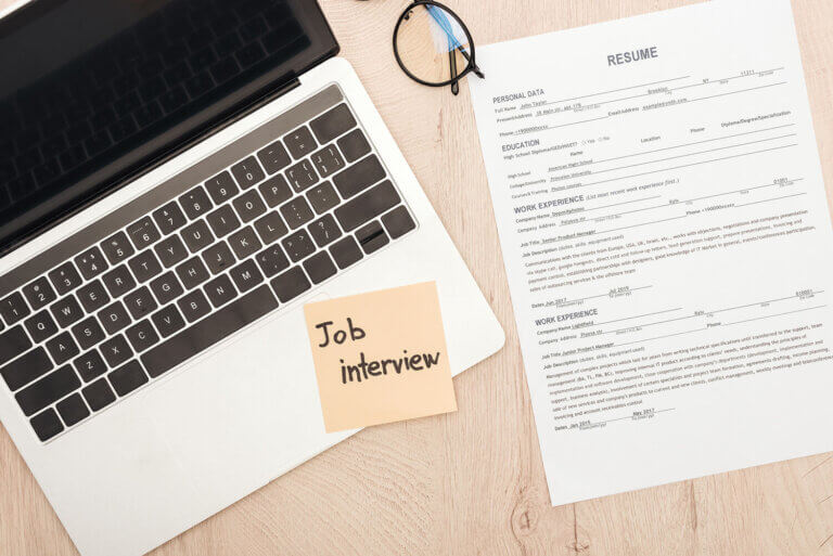 Job interview concept. Laptop and resume on a desk.