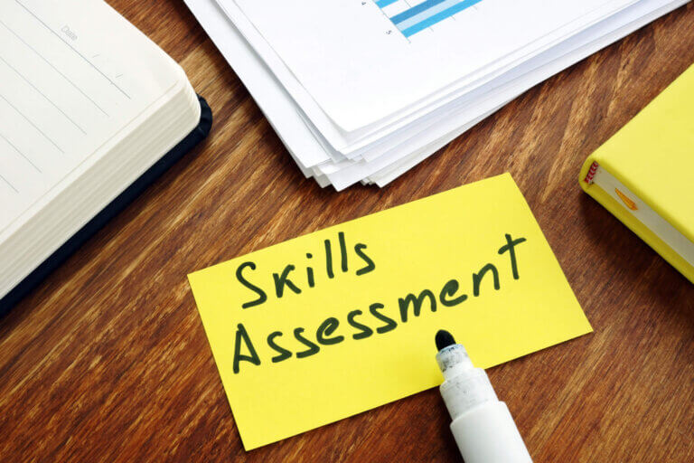 The phrase skills assessment written on a sticky note on a desk.