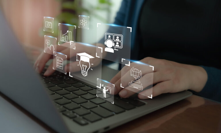 Person’s hands on keyboard of a laptop with icons floating. Artificial intelligence concept.