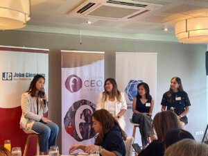  a panel of women on stools speaking to audience