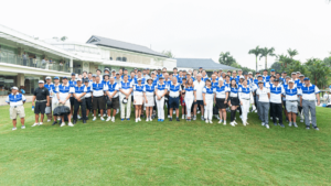 a big group posing for a photo on a golf course