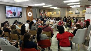 event attendees in a full room listening to speaker