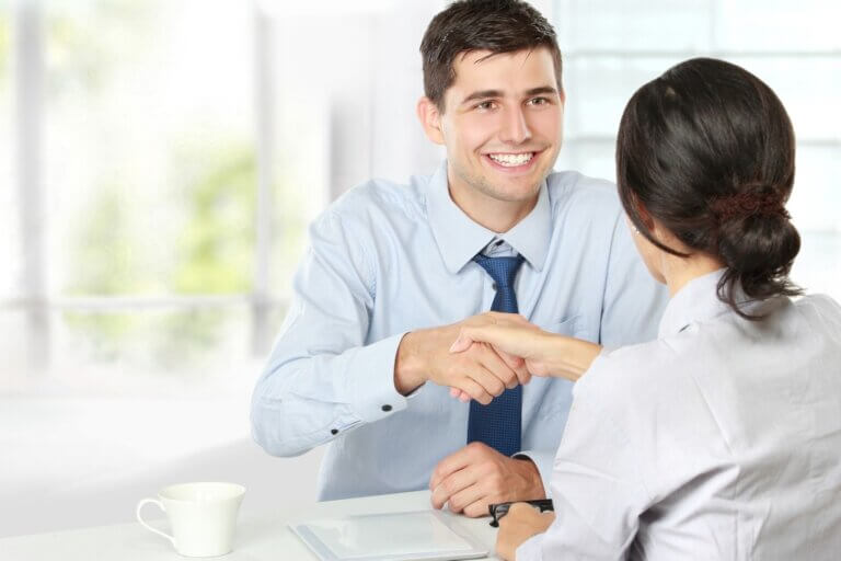 man shaking woman's hand in interview