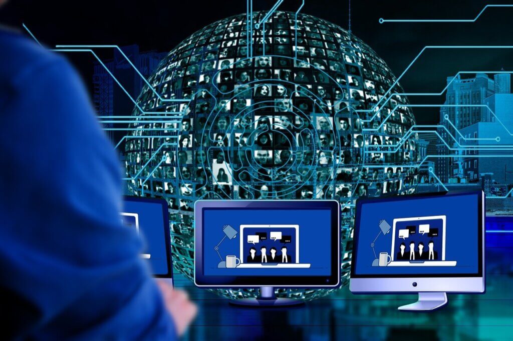 illustration of man working on multiple monitors with a globe of different people in the background