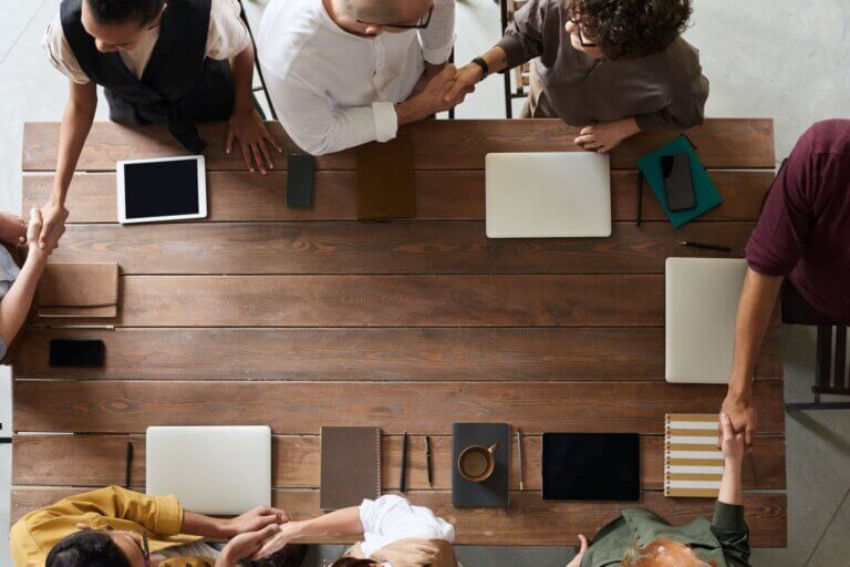 Top View Photo of People Handshaking around a table