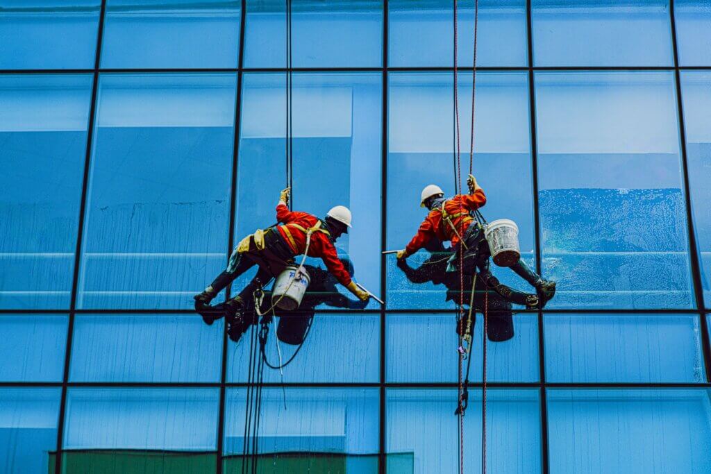 two men cleaning windows of a building