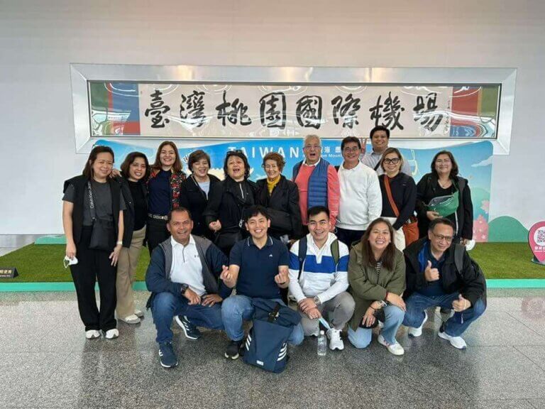 John Clements Leadership Team standing in front of Taiwan banner