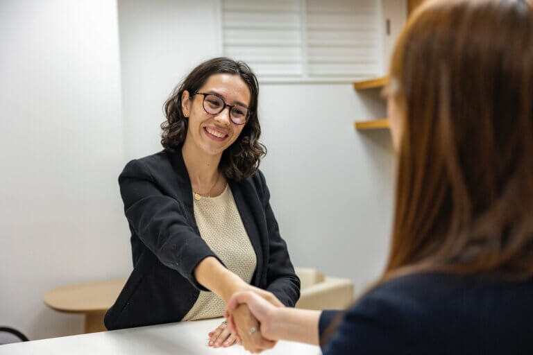 Young Woman in Business Attire Shaking Hands With Recruiting Manager After Job Interview