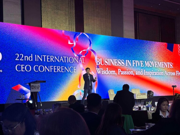 Matty Lin presenting on the transformative power of Generative AI at the 22nd International CEO Conference, with a large stage backdrop displaying the event’s theme, 'Business in Five Movements: Wisdom, Passion, and Inspiration Across Five Eras.' A podium with the MAP (Management Association of the Philippines) logo is also visible.