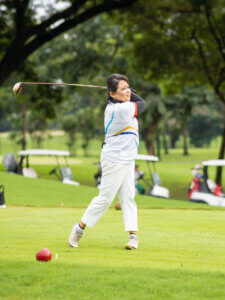 Female golfer swinging her golf club.