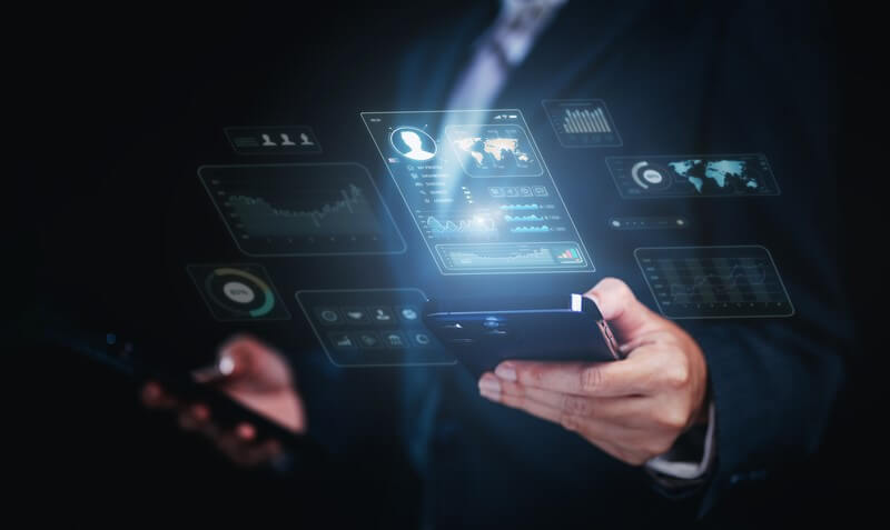 A professional holding a smartphone with futuristic holographic displays, showcasing digital profiles and data analytics, representing how to boost personal brand for job hunting using modern technology.