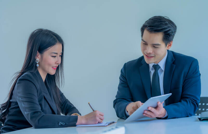 Two professionals engaged in an executive coaching session, reviewing notes and strategies.