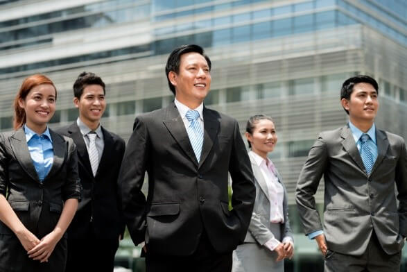 Five professionals in business attire standing confidently outdoors, symbolizing expertise in executive search and leadership recruitment.