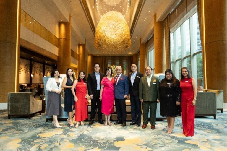 Group photo of attendees at EDI-Staffbuilders’ 45th Anniversary celebration in an elegant hotel lobby with warm lighting and sophisticated decor.