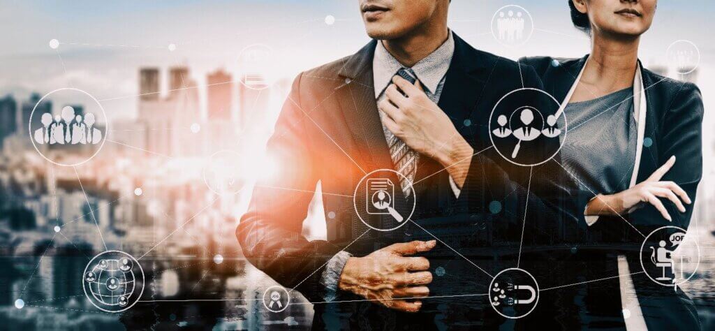 A professional man and woman in business attire stand confidently against a city skyline, surrounded by icons representing connection and recruitment, illustrating holiday networking tips.