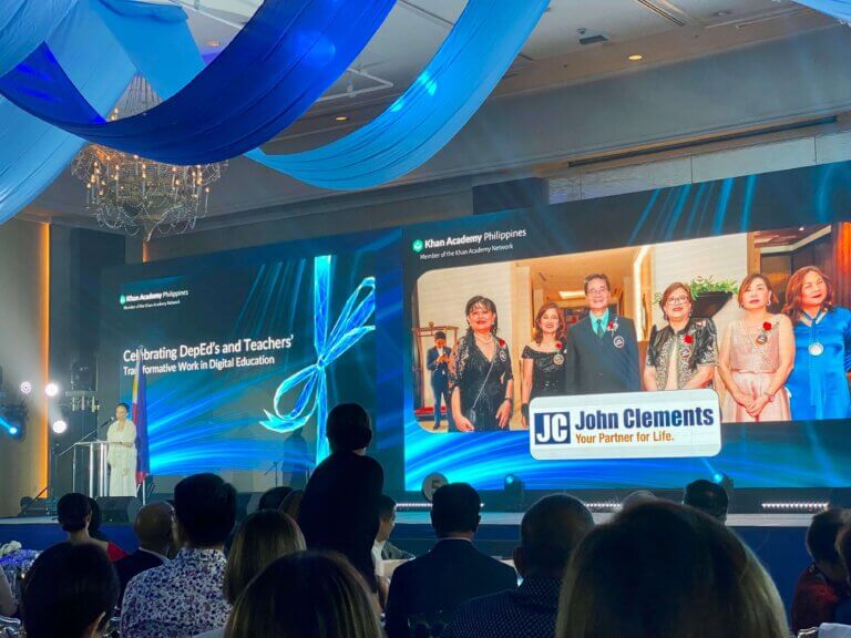 A woman speaking on stage at an event focused on transforming education in the Philippines.