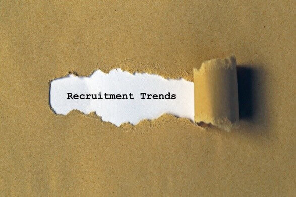 A torn paper revealing the words “Recruitment Trends,” symbolizing emerging hiring trends in 2025.