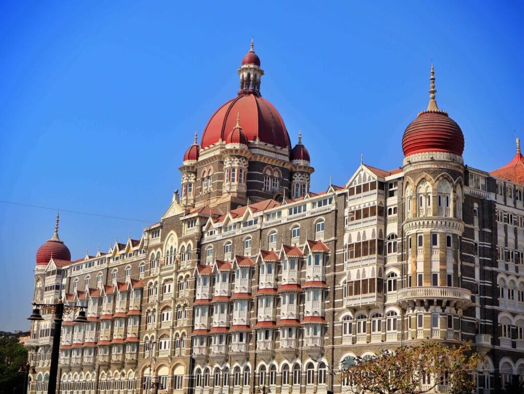 Historic architecture in Mumbai, featuring the iconic Taj Mahal Palace Hotel against a clear blue sky.