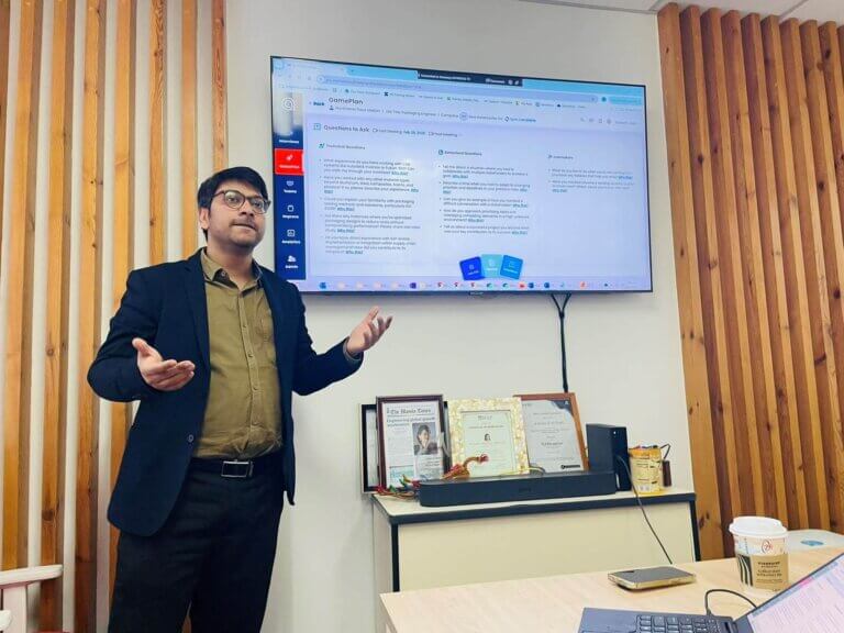 Professional presenting AI recruitment software interface on a screen during a meeting.