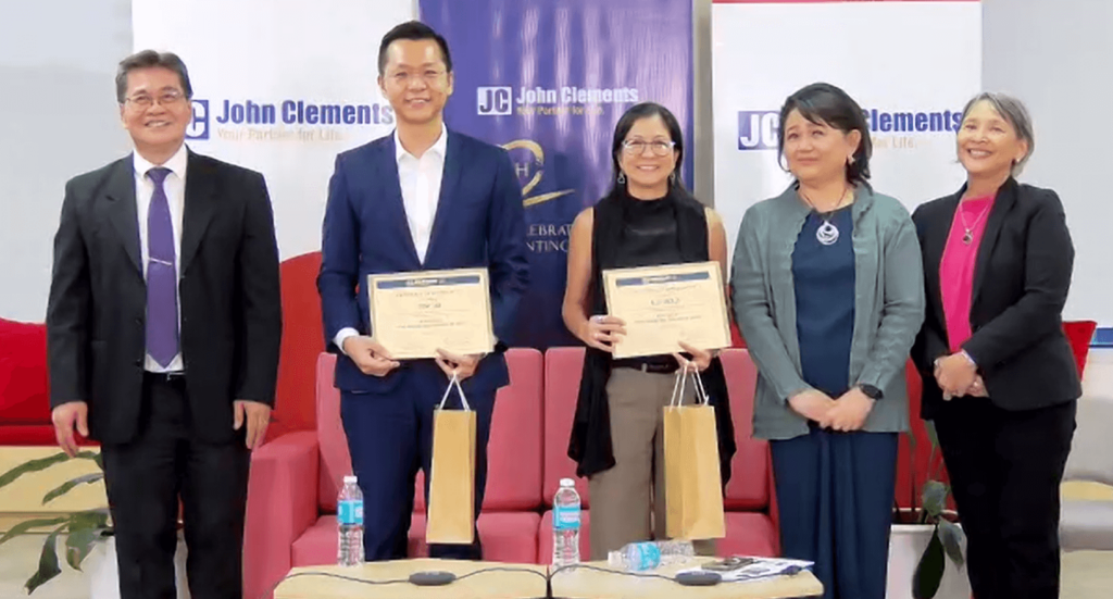 Speakers and hosts pose with certificates and gift bags after a discussion on consumer trends in snacking at a John Clements Consultants event.