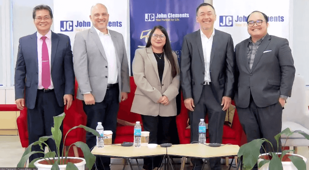 Business professionals standing in front of a branded backdrop, symbolizing collaboration and progress in shared services transformation.
