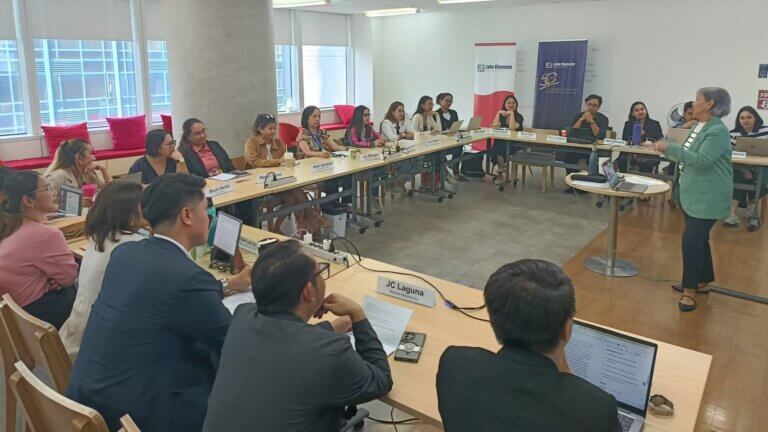 A group of professionals attentively listens to a speaker during a workshop on emotional intelligence in leadership, held in a modern conference room.