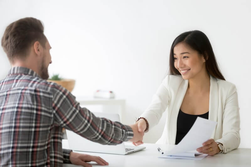 Executive search firms facilitating a professional interview handshake.