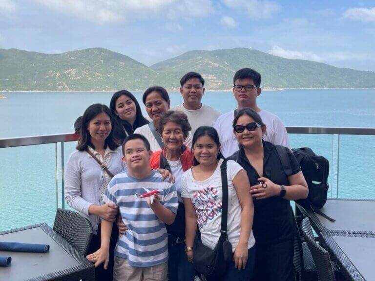 A family poses together on a balcony overlooking the sea and mountains during Holy Week in Hong Kong.