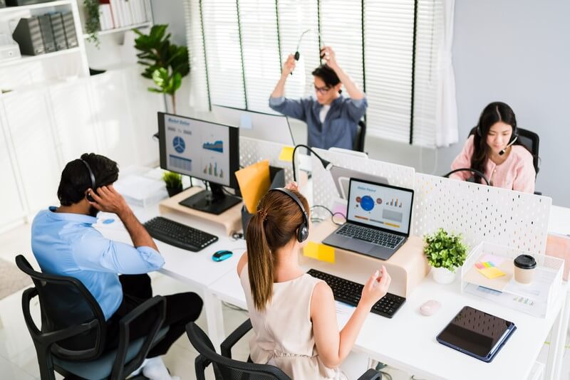 Reskilling for tech-driven workforce in the Philippines: Professionals collaborate in a modern office, analyzing data on computer screens, highlighting the importance of digital upskilling in today's evolving job market.