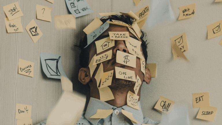 Person overwhelmed by sticky notes with reminders like 'CHILL,' 'DEADLINE,' and 'TAKE A BREAK'—visually representing stress and mental clutter.